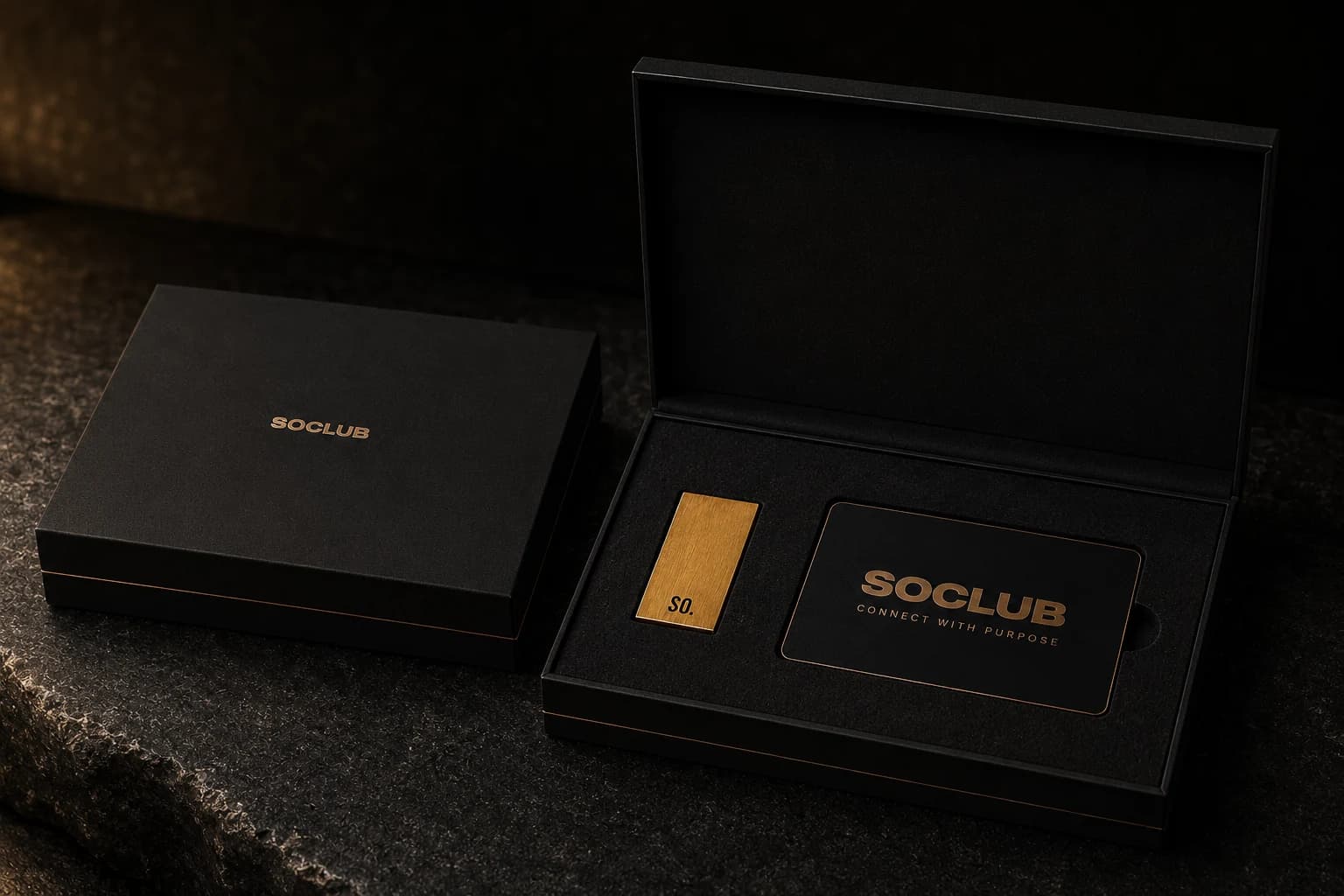 A matte black SOCLUB presentation box with a brass mark and printed card.